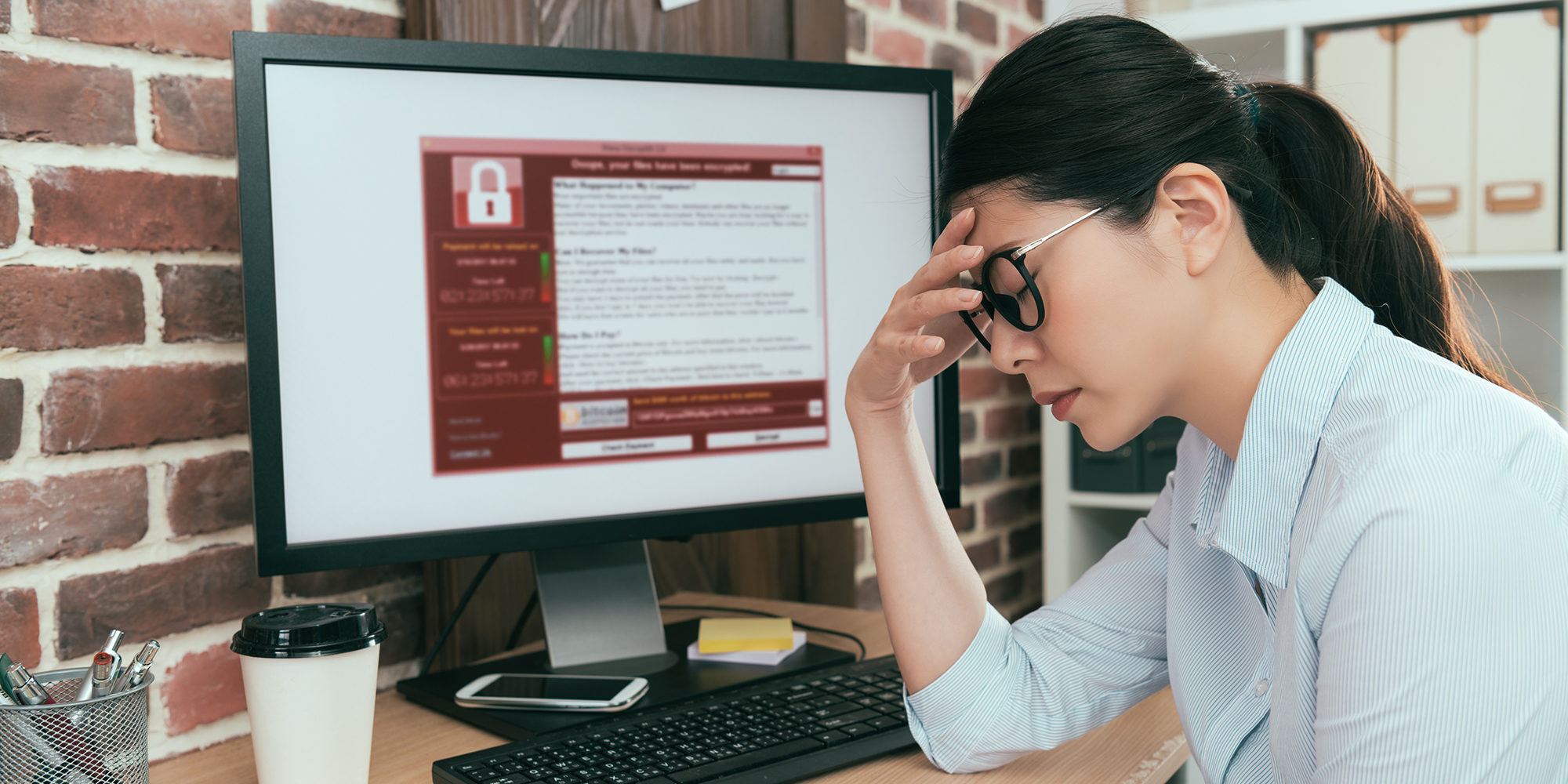 Vrouw die met de handen in de haren zit en merkt dat haar computer gehackt is.