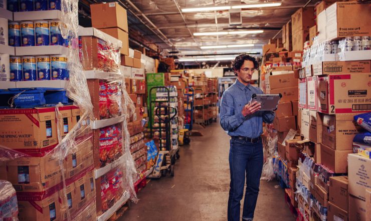 Man inside a warehouse looking at a tablet