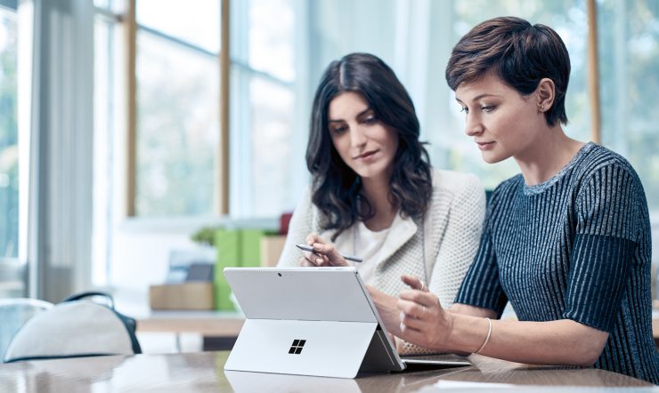 2 women working on a Microsoft Surface