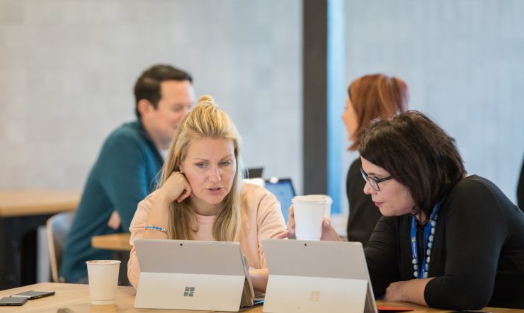 2 people meeting with two surfaces on the table