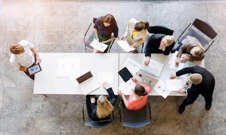 the image looks down on 7 people having a meeting