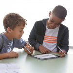 2 kids playing on a Surface Go