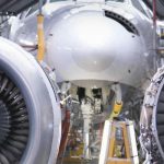 Two field workers fixing airplane turbines