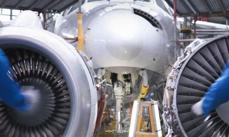 Two field workers fixing airplane turbines