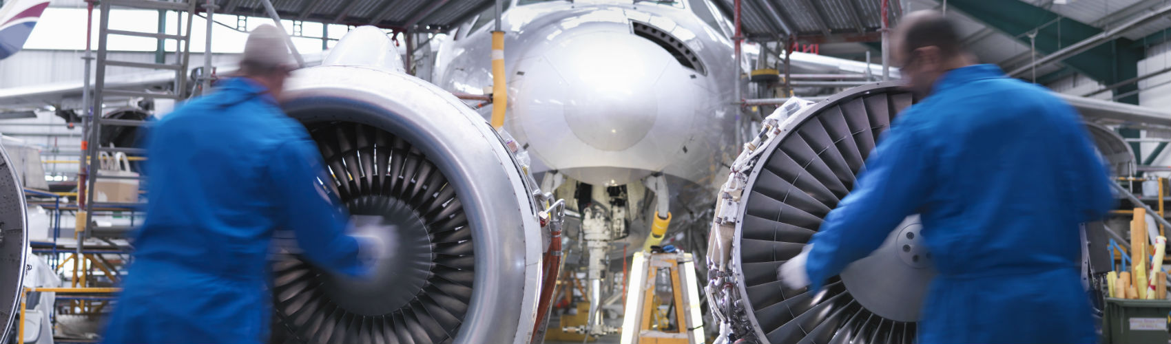 Two field workers fixing airplane turbines