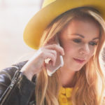 Woman with yellow hat calling