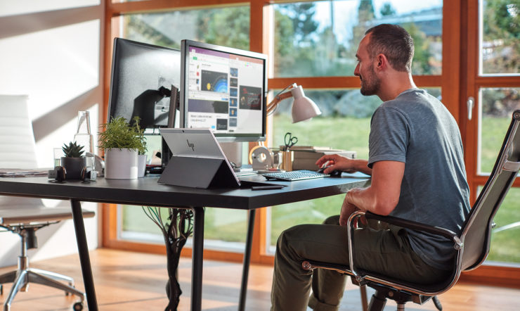 Uma pessoa a trabalhar num computador num escritório com vários dispositivos