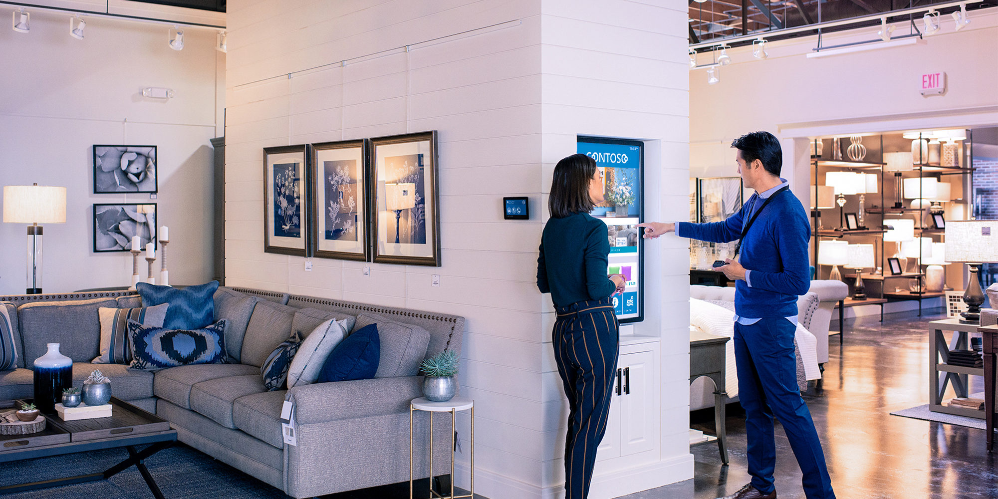 Les employés d’un magasin regardent un écran en le pointant du doigt