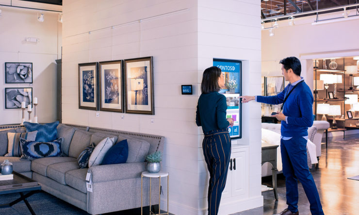 Store staff llooking and pointing at screen