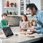 Image of Dad Baking with Kids and Device