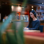 Image of a woman on her laptop in a coffee shop