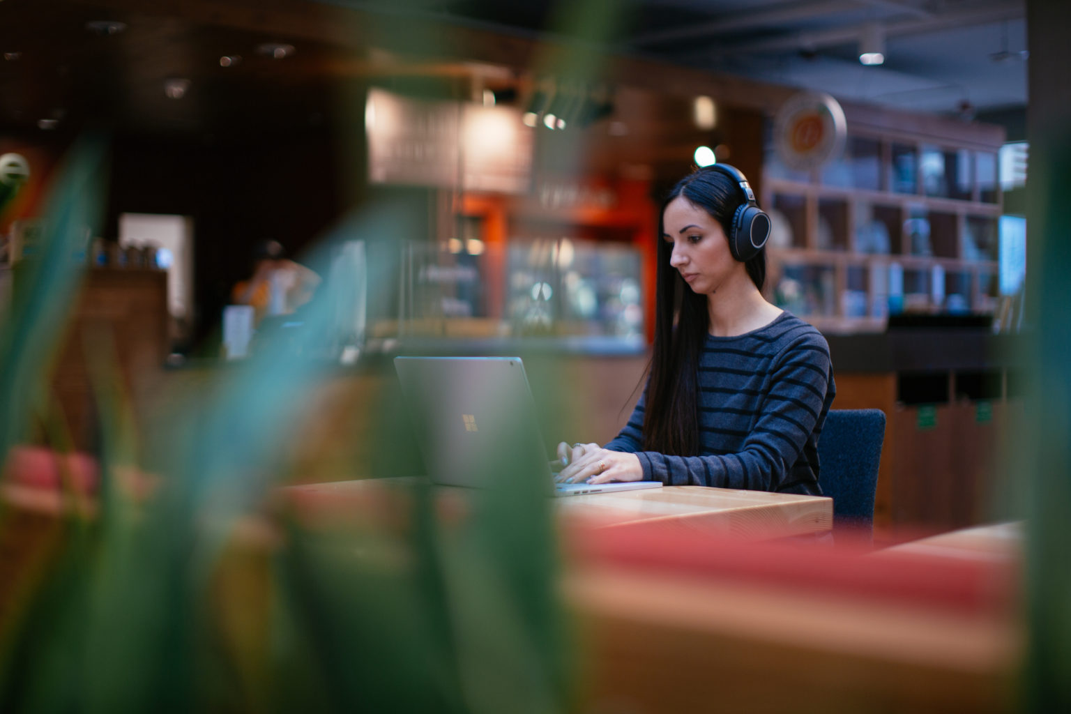 Image of a woman on her laptop in a coffee shop