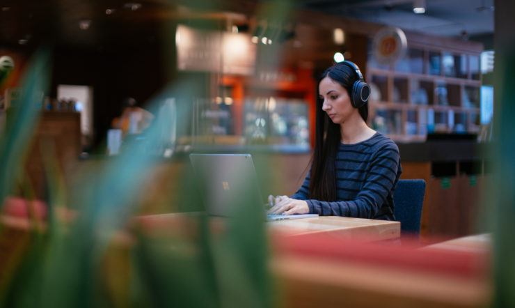 Image of a woman on her laptop in a coffee shop