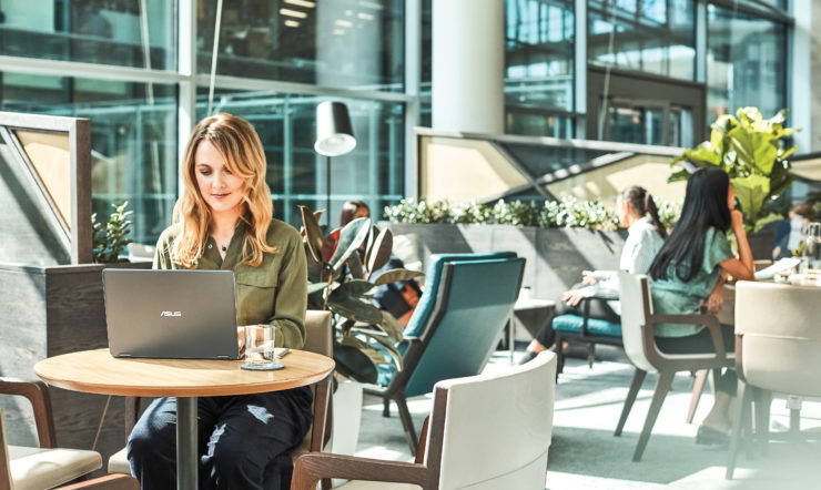 Woman interacting with an Asus NovaGo laptop.