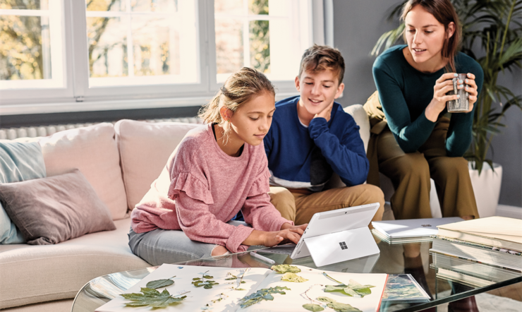Family, mother and 2 student kids at home working, typing on Surface Go