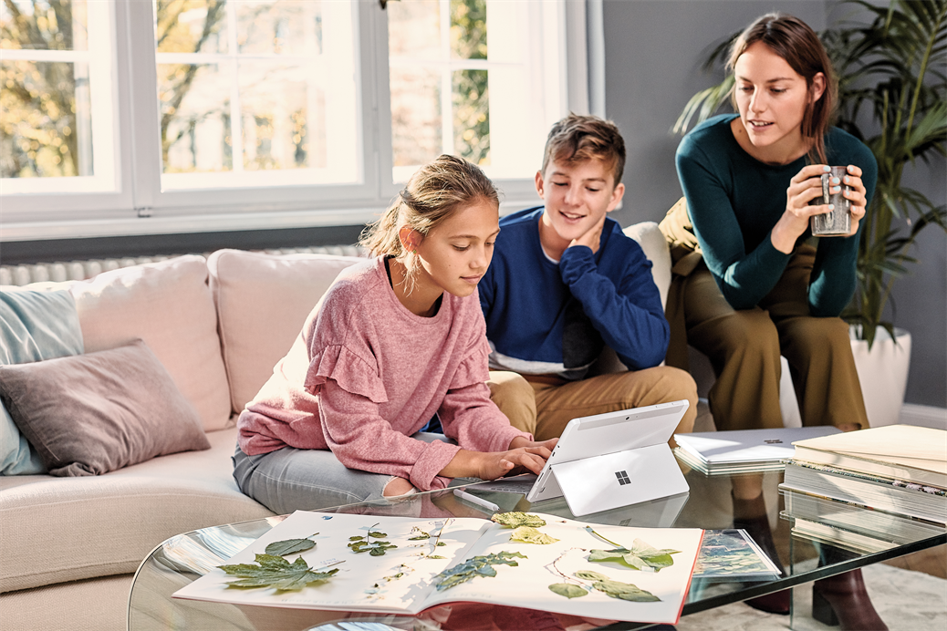 Family, mother and 2 student kids at home working, typing on Surface Go