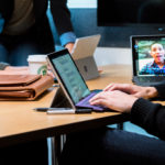 A group opf people around a desktop having a Teams meeting