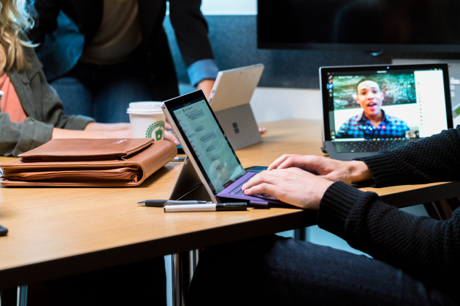 A group opf people around a desktop having a Teams meeting