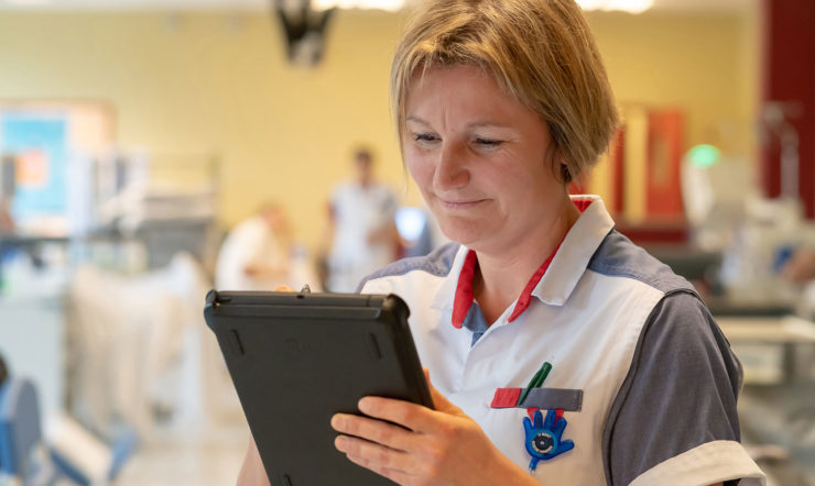 Verpleegkundige Katrien Van Ouytsel poserend met een tablet.
