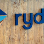 Rydoo-logo op houten wand.