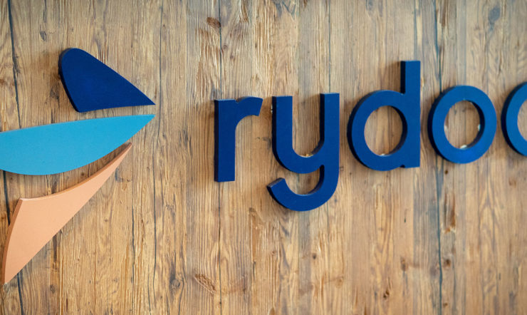 Rydoo-logo op houten wand.