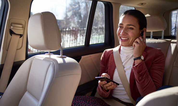 En kvinde sidder i en taxi og taler i telefon