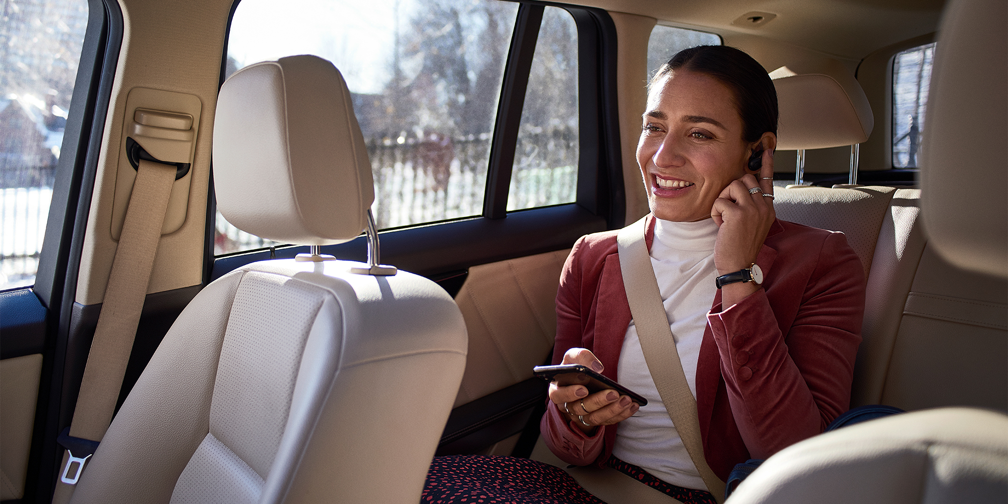 En kvinde sidder i en taxi og taler i telefon