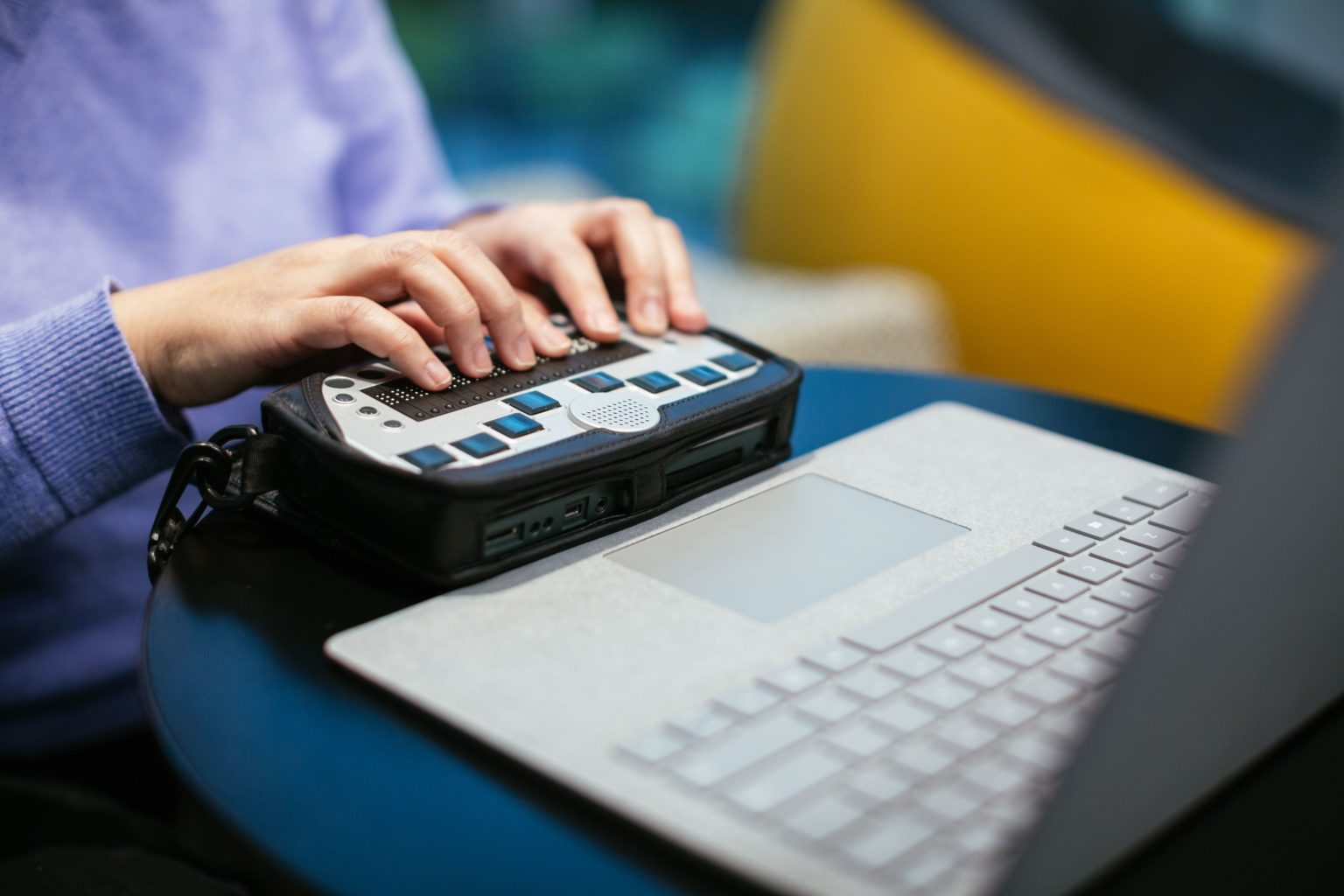 Anne Taylor, a woman who is blind, uses a braille keyboard with a Surface device
