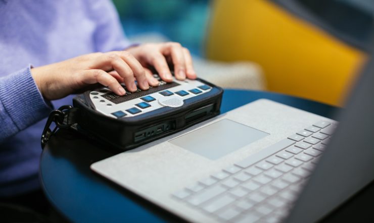 Anne Taylor, a woman who is blind, uses a braille keyboard with a Surface device