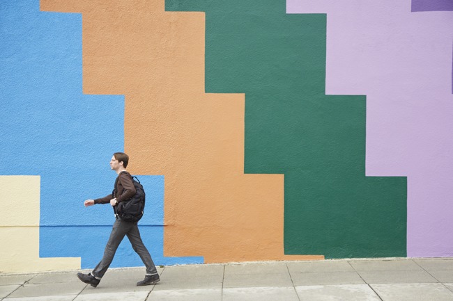 Man loopt voorbij een muur in een stad