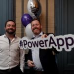 David Arnold & Paul Gilbride holding a PowerApps sign posing for the camera