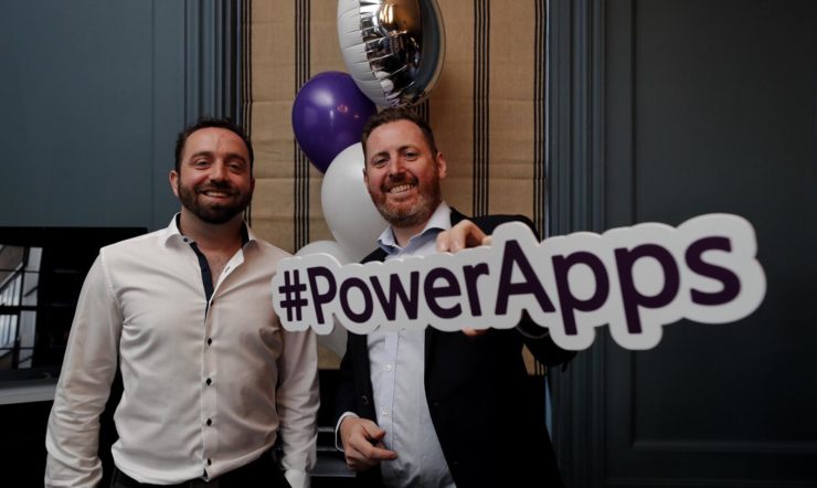 David Arnold & Paul Gilbride holding a PowerApps sign posing for the camera