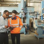 A man at a factory looking at a tablet