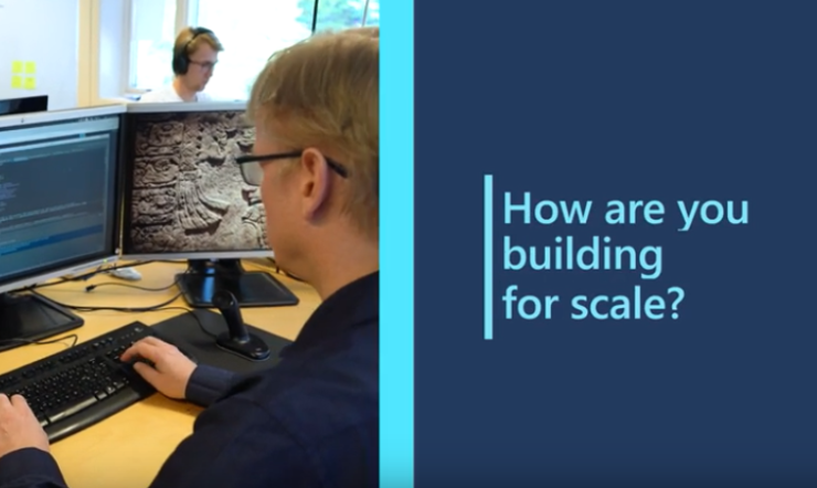en person som sitter ved et skrivebord og ser på en dataskjerm