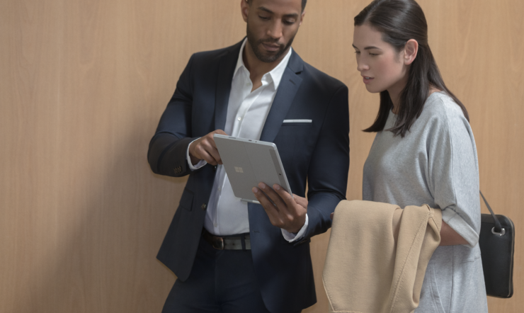 Two people inside using Surface Go in office