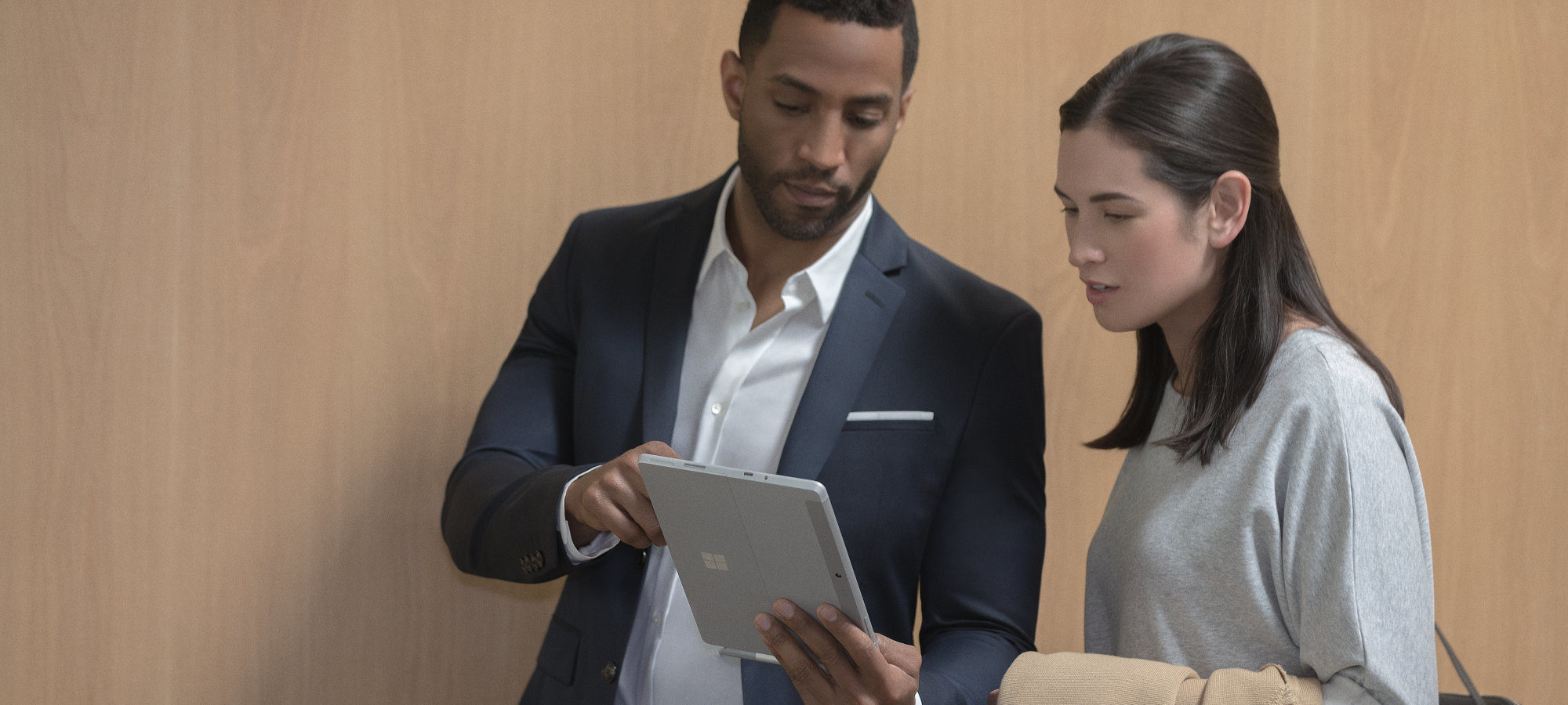 Twee mensen binnen die Surface Go in hun bureau gebruiken