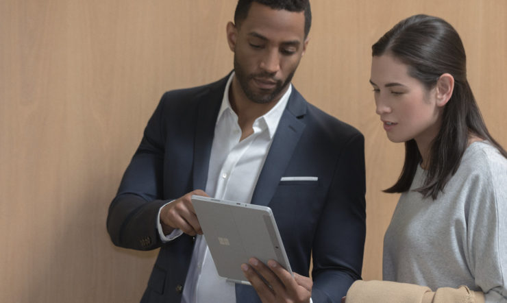 Zwei Menschen, die ein Surface Go im Büro verwenden