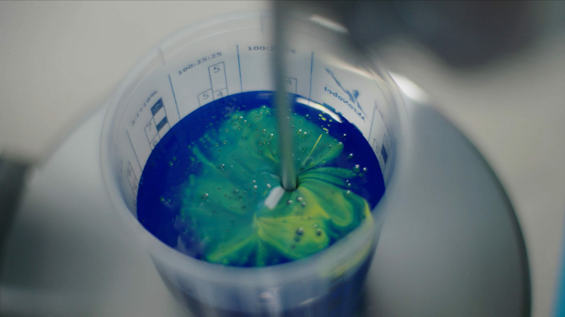 et nærbillede af en flaske med blå og grøn maling