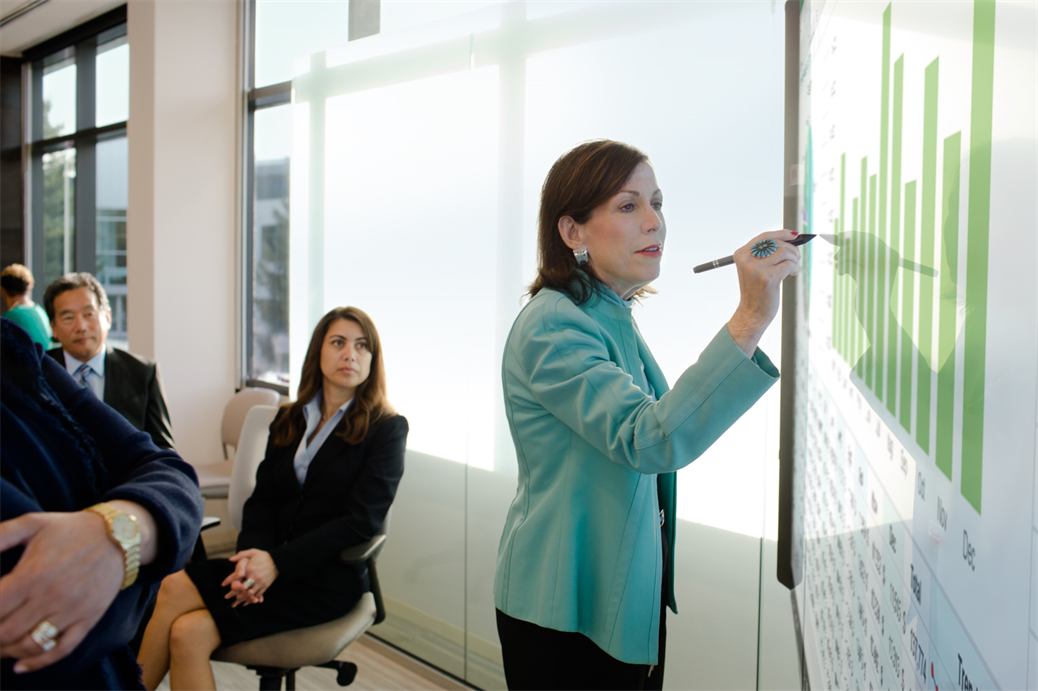 CFO going over numbers in a meeting using the Surface Hub. Business attire