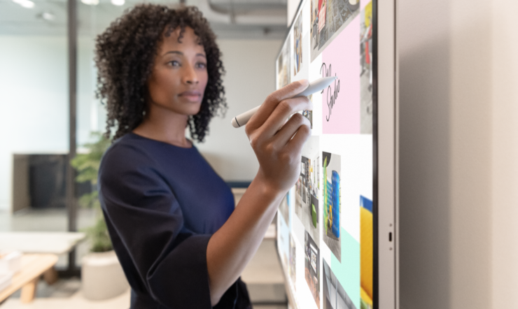 Woman executive working on Surface Hub 2S in Whiteboard with Surface Hub 2 Pen