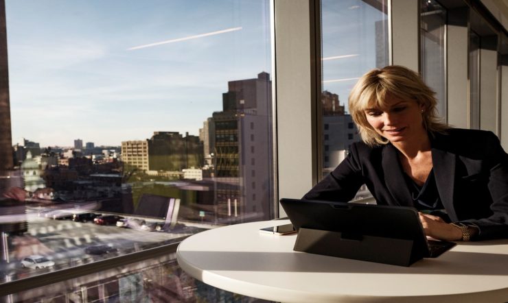 a woman sitting at a table in front of a building