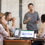 a group of people looking at a laptop