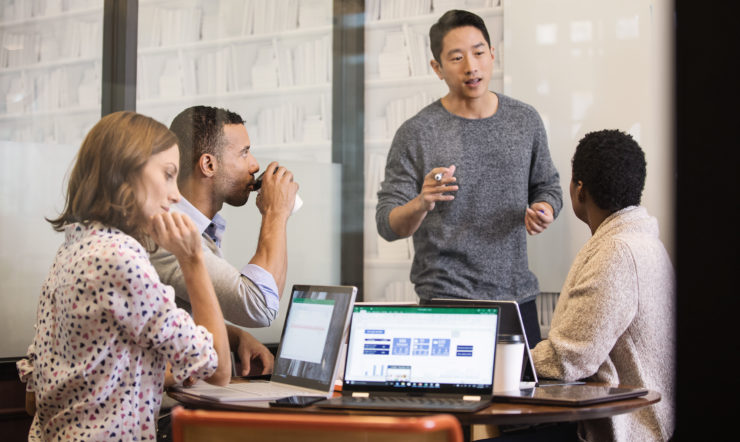 a group of people looking at a laptop