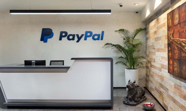 A large reception desk in the middle with a ginat painting on the wall