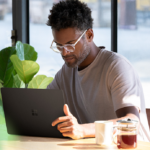 Contextual image of man working on black Surface Laptop 2 inside