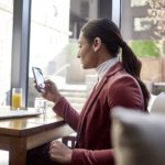 un personne assise à une table devant une fenêtre