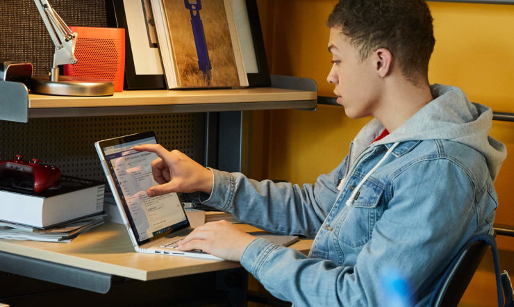 een man gebruikt een laptop op een bureau