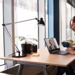 iemand zit aan een bureau met een laptop op tafel