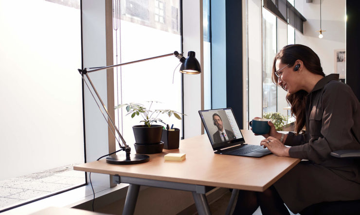 Eine Person, die an einem Tisch sitzt und mit einem Laptop arbeitet