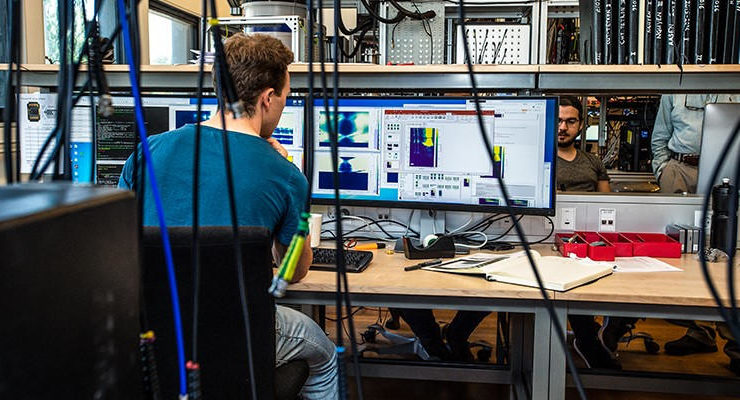 um homem sentado a uma secretária à frente de um computador